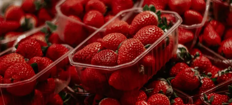 Fresh strawberries in clear plastic containers, with a focus on the center